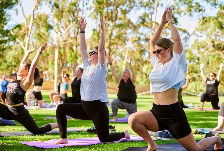 people doing yoga in the park
