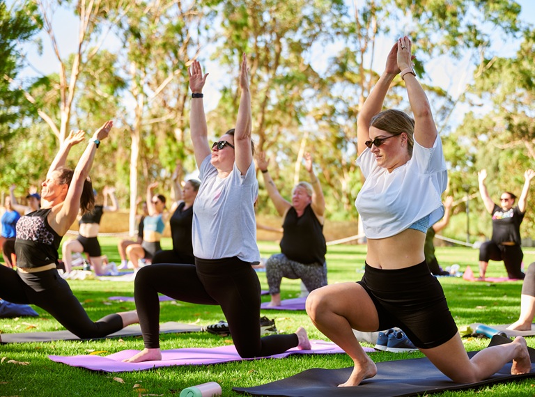 people doing yoga in the park