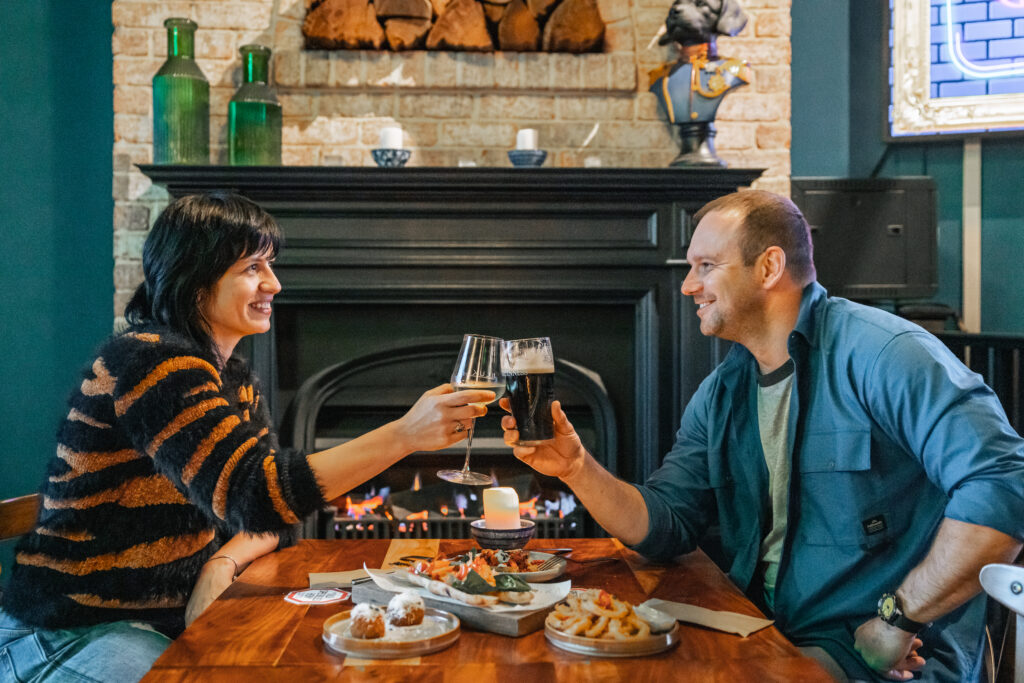 Two people having a drink and some food in a pub